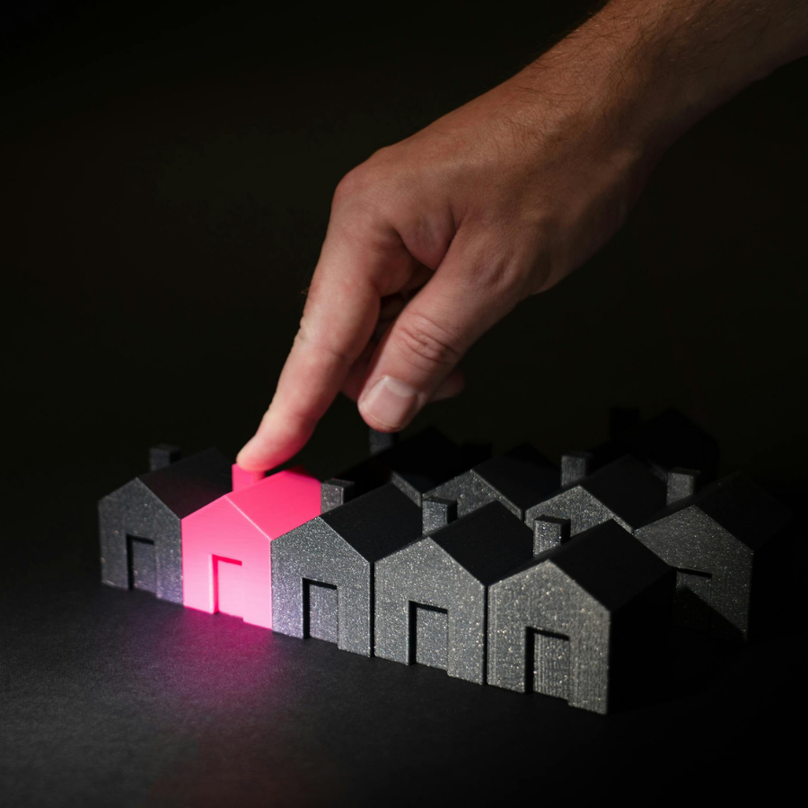 Hand selecting a glowing pink home model