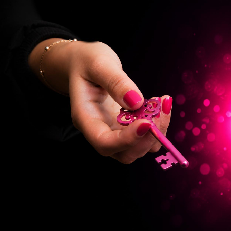 Hand holding a glowing pink key
